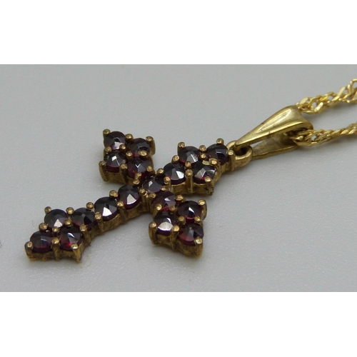 1063 - A 9ct gold and garnet set cross pendant on a 9ct gold chain, 3.9g