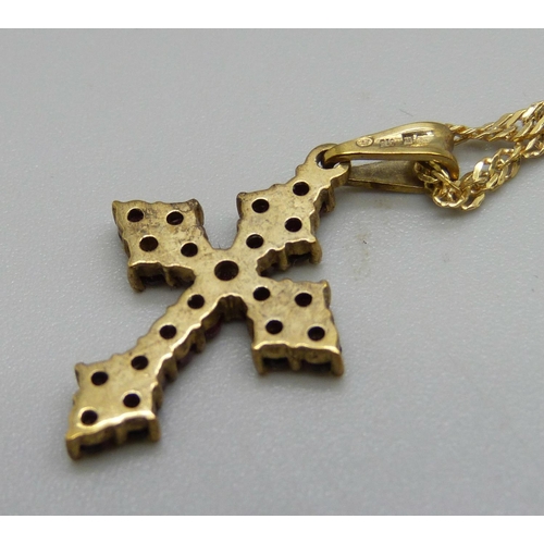 1063 - A 9ct gold and garnet set cross pendant on a 9ct gold chain, 3.9g