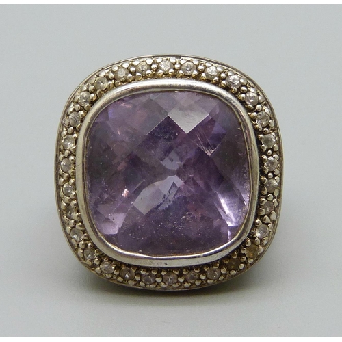 1067 - A large silver set ring with an amethyst coloured stone, N