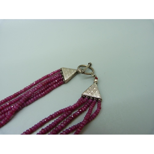 1078 - A five strand ruby bead necklace