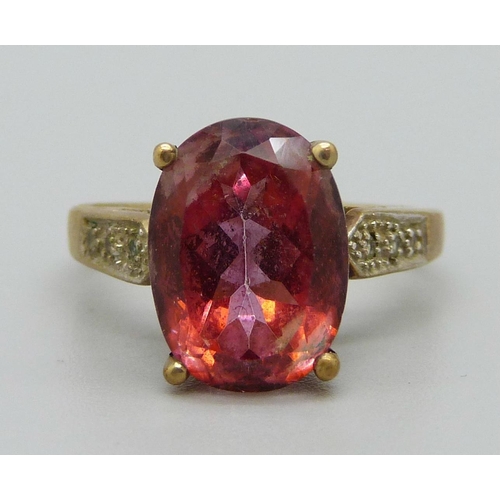 1089 - A 9ct gold ring set with a red stone, 5.4g, T