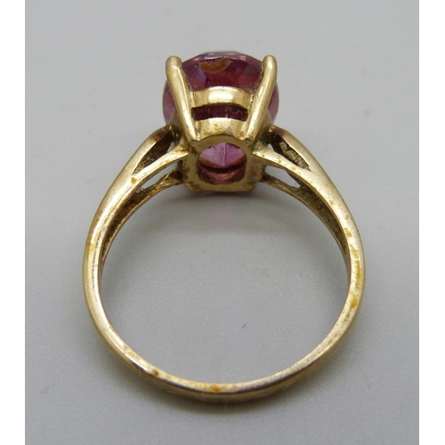 1089 - A 9ct gold ring set with a red stone, 5.4g, T