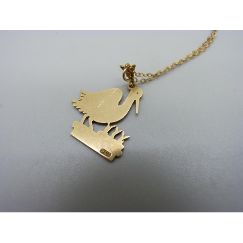 1123 - A 9ct gold 'stork' pendant on a yellow metal chain, total weight 3.7g