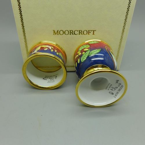 629 - A Moorcroft handkerchief flower enamel egg cup and napkin ring, boxed