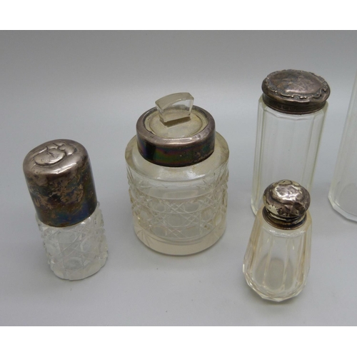 867 - A collection of seven silver topped bottles, scent and salts jar, including Victorian