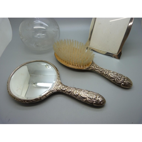 929 - A silver photograph frame, 11cm x 15cm, a silver brush and mirror and silver rimmed bottle lacking s... 