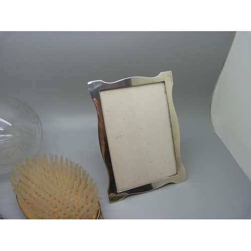 929 - A silver photograph frame, 11cm x 15cm, a silver brush and mirror and silver rimmed bottle lacking s... 