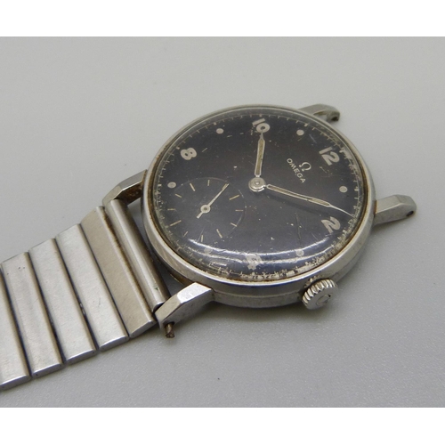 971 - A 1950's Omega wristwatch with black dial and sub dial second hand, manual wind, 31mm case