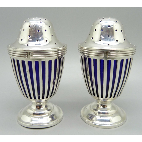 857 - A pair of silver pepperettes with blue glass liners, London 1908, 75g