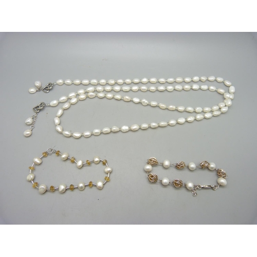 954 - A pearl necklace and two bracelets