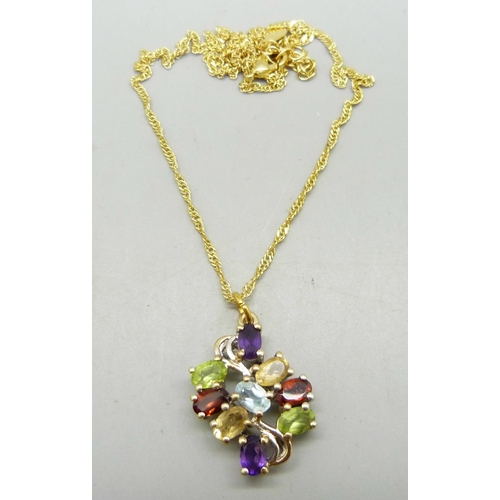 983 - A silver gilt pendant set with peridot, garnet, amethyst, topaz and citrine, etc., on a chain