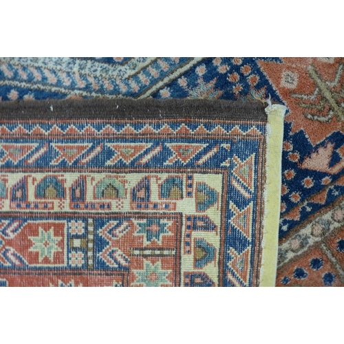 187 - An eastern salmon pink and blue ground hand knotted rug, 337 x 275cms