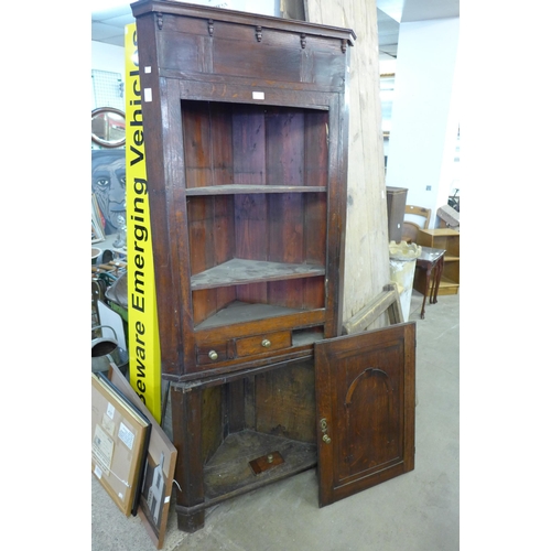 326 - A George III oak splay front corner cupboard, on associated base