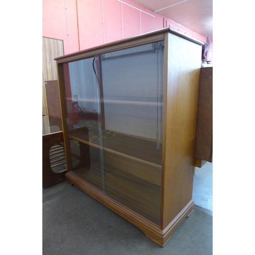 87 - A teak and smoked glass topped coffee table and a small teak bookcase