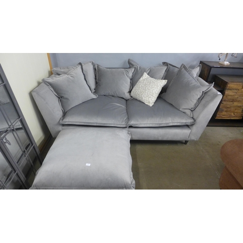 1407 - A grey velvet scatter back three seater sofa and footstool