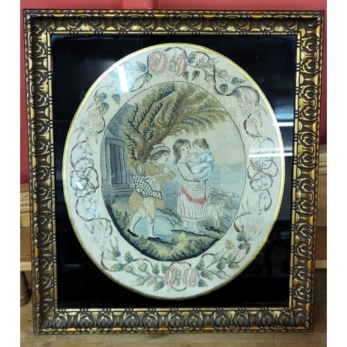 299a - A Regency oval silkwork, depicting a young couple with baby, within a border of flowers and swags, c... 