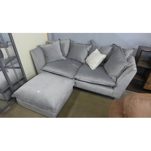 1406 - A grey velvet scatter back three seater sofa and footstool