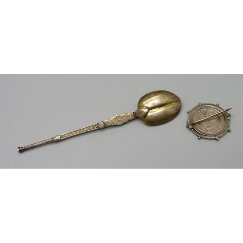 1064 - A silver spoon and a Victorian 1887 coin in brooch mount