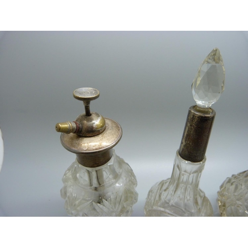 814 - A collection of five silver mounted glass scent bottles, one stopper chipped