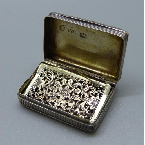 824 - A silver vinaigrette, inner cover a/f, a silver florin and a silver stamp pendant