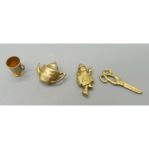 976 - Four 9ct gold charms; teapot, drinking cup, pair of scissors and witch on a broom, 2.7g