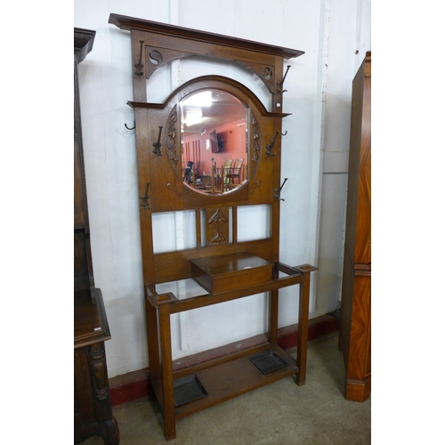 120 - An Art Nouveau carved oak mirrored hall stand