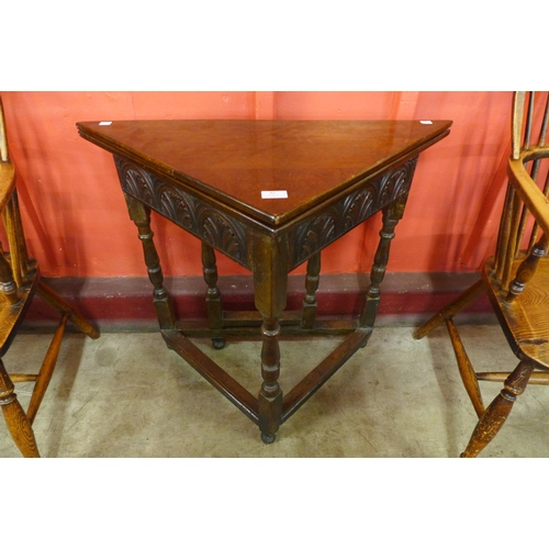 83 - A 17th Century style carved oak fold over corner table