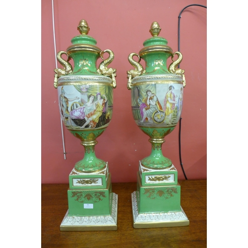 93 - A pair of Italian style green porcelain and gilt vases and covers, decorated with romantic scenes