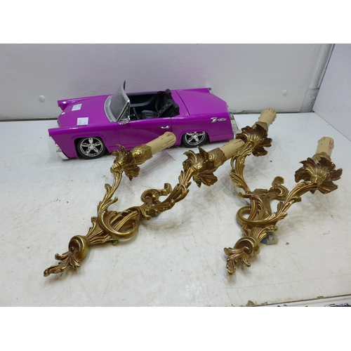 2210 - A pink Cadillac toy with a pair of brass wall lights