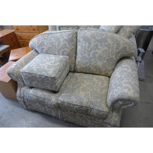 1672 - A magnolia and teal floral upholstered two and three seater sofas