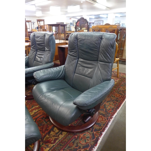 34 - A pair of stained beech and green leather revolving lounge chairs and matching foot stools