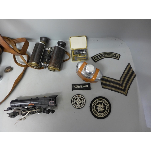 722 - A pair of binoculars, cloth badges, a locomotive, a/f, a leather binoculars case, etc.