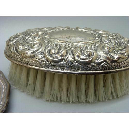 812 - A silver backed brush, a silver topped jar, top a/f, an ebony and applied silver mirror and letter o... 