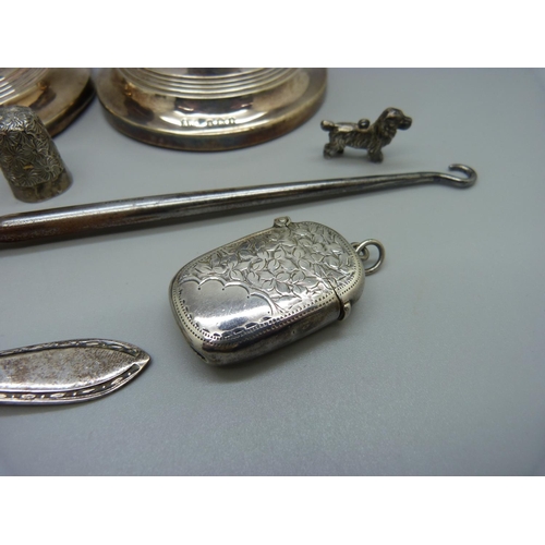 821 - A pair of small candlesticks, one a/f, a silver vesta case, a silver pusher, a silver napkin ring, e... 