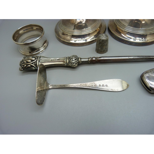 821 - A pair of small candlesticks, one a/f, a silver vesta case, a silver pusher, a silver napkin ring, e... 