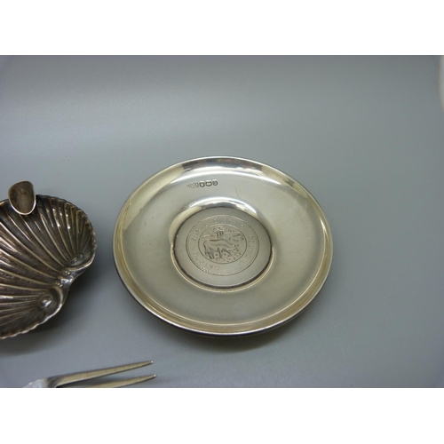 828 - Six silver items; a vase, two napkin rings, dish, a fork and a spoon, and a white metal shell shaped... 