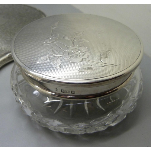 835 - A silver backed hand mirror with two matching brushes, one other silver backed hand mirror, a silver... 