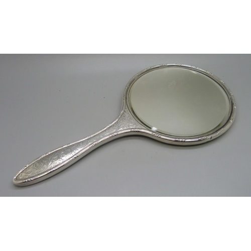 835 - A silver backed hand mirror with two matching brushes, one other silver backed hand mirror, a silver... 