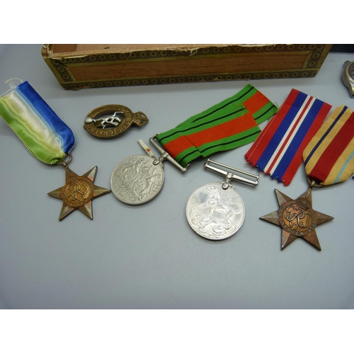 867 - A collection of WWII medals, a service book, a Signals badge, a Nottingham School attendance medal a... 