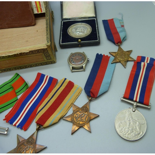 867 - A collection of WWII medals, a service book, a Signals badge, a Nottingham School attendance medal a... 