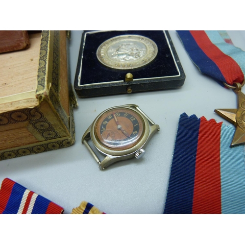 867 - A collection of WWII medals, a service book, a Signals badge, a Nottingham School attendance medal a... 