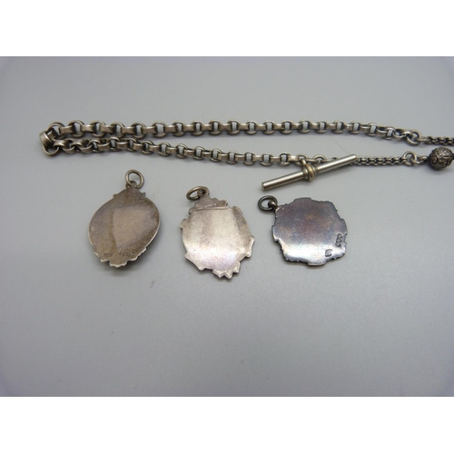 901 - An Albert chain and three silver fobs including one football