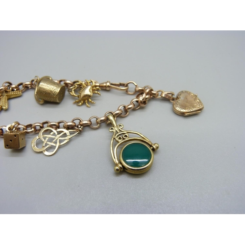 964 - A 9ct gold bracelet with nine charms, two charms hallmarked 9ct gold, the others marked 9k, 9ct or 3... 