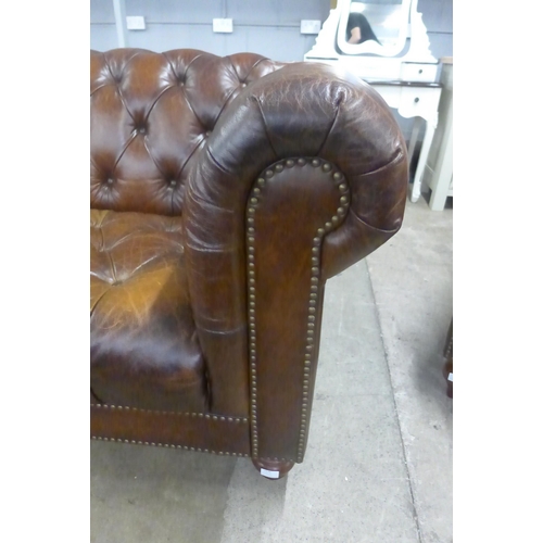 1570 - A brown leather Chesterfield three seater sofa