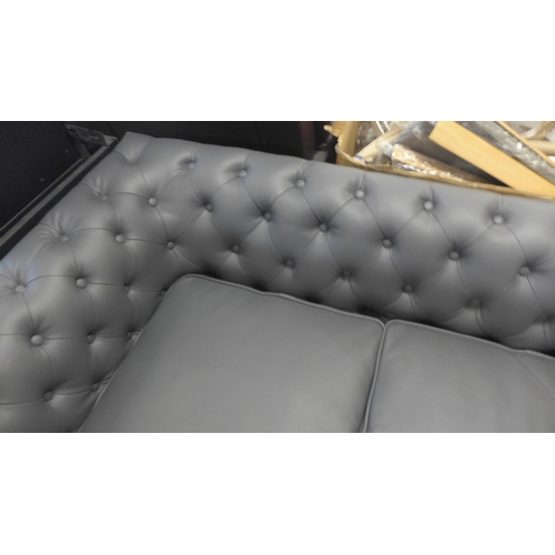 1648 - A grey leather effect Chesterfield style three seater sofa, some marks, damaged cushion