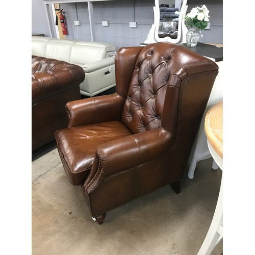 1571 - A brown leather buttoned wingback armchair