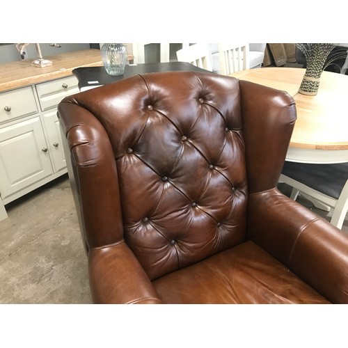 1571 - A brown leather buttoned wingback armchair