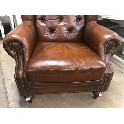 1571 - A brown leather buttoned wingback armchair