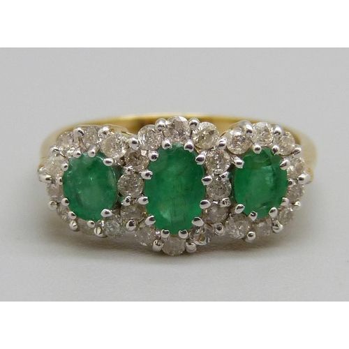 1038 - An 18ct gold, emerald and diamond triple cluster ring, 0.50ct diamond weight marked in the shaft, 3.... 