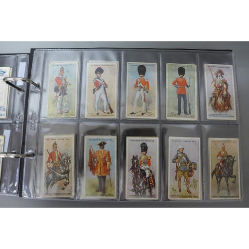 693 - Cigarette cards;-an album of military related cards with eleven complete sets including Player’s Vic... 